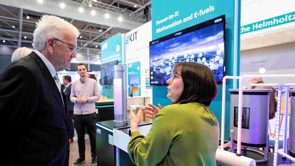 Katja Haas-Santo informs Winfried Kretschmann about the Energy Lab's research on Power-to-X: Methanation and E-fuels on April 17 at the Hannover Messe at KIT Energy Solutions.
